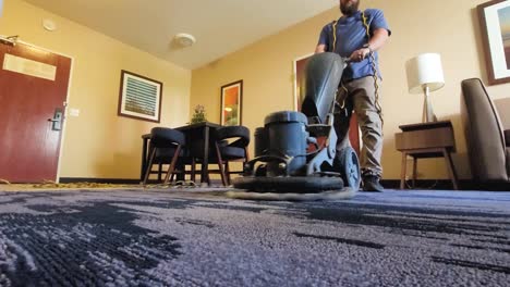 young male worker cleaning carpet