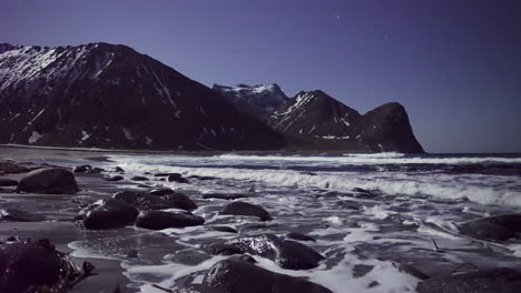 las olas rompen en la costa rocosa de la playa de unstad al atardecer en las islas lofoten, noruega