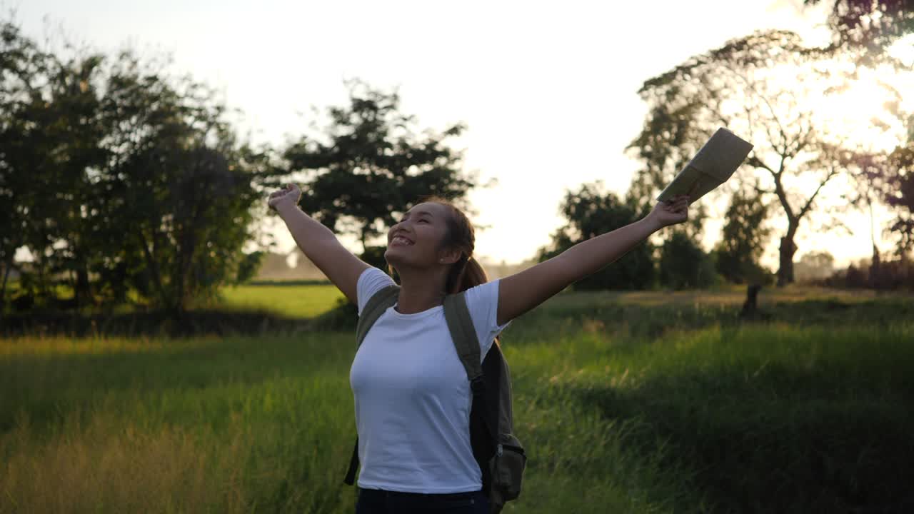 mujer levantando las manos relajarse después de caminar mucho el camino