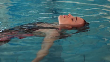 mujer atractiva relajándose en la piscina