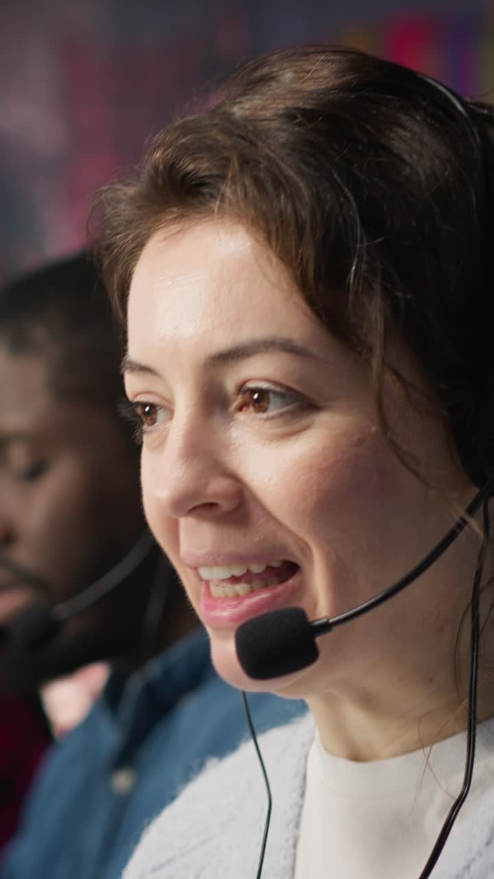 Video verticale. Un operatore di call center felice in ufficio che aiuta i clienti rispondendo alle domande.