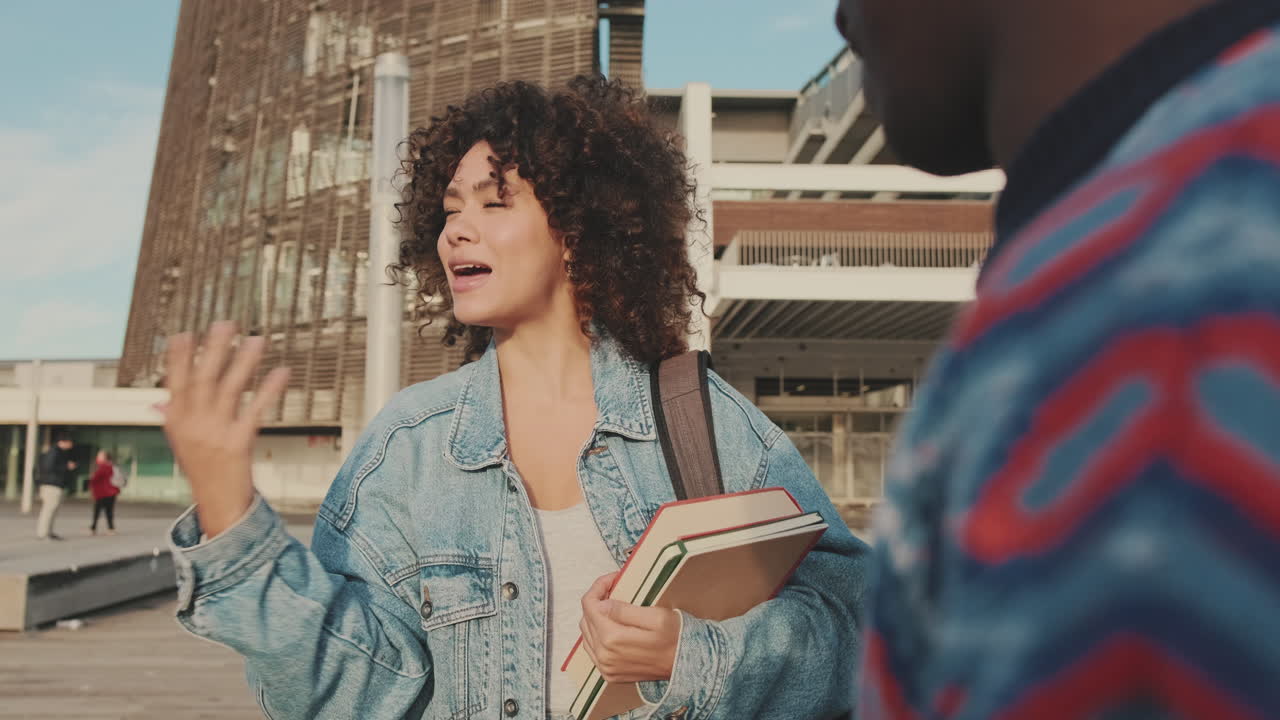Group of students talking with books on campus