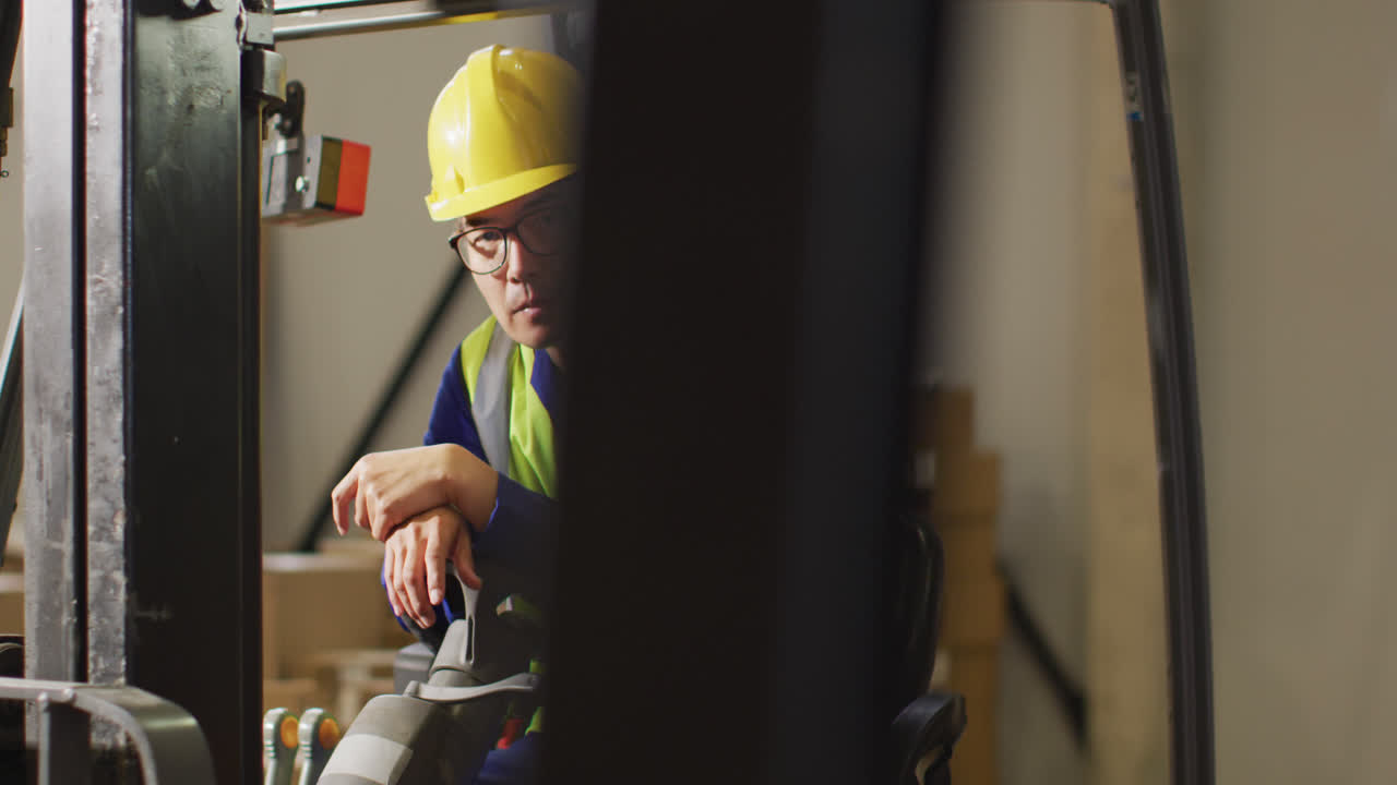 Portrait of asian male worker wearing safety suit in warehouse