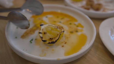 grilled lemon on a sauce-covered plate