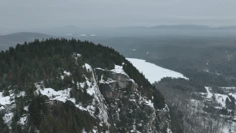 mountain landscape with coniferous trees during winter in quebec, canada - aerial drone shot