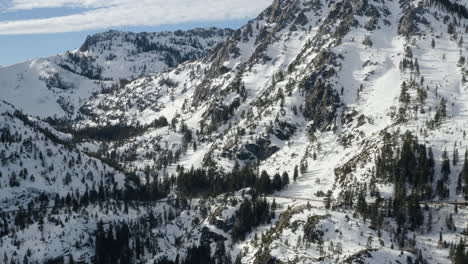 aerial of the mountains surrounding emerald bay lake tahoe with cars moving along highway 89
