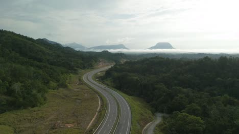 beautiful drone view of bau to lundu pan borneo highway during morning sunset with mountain and valley, green forest,sarawak, borneo.