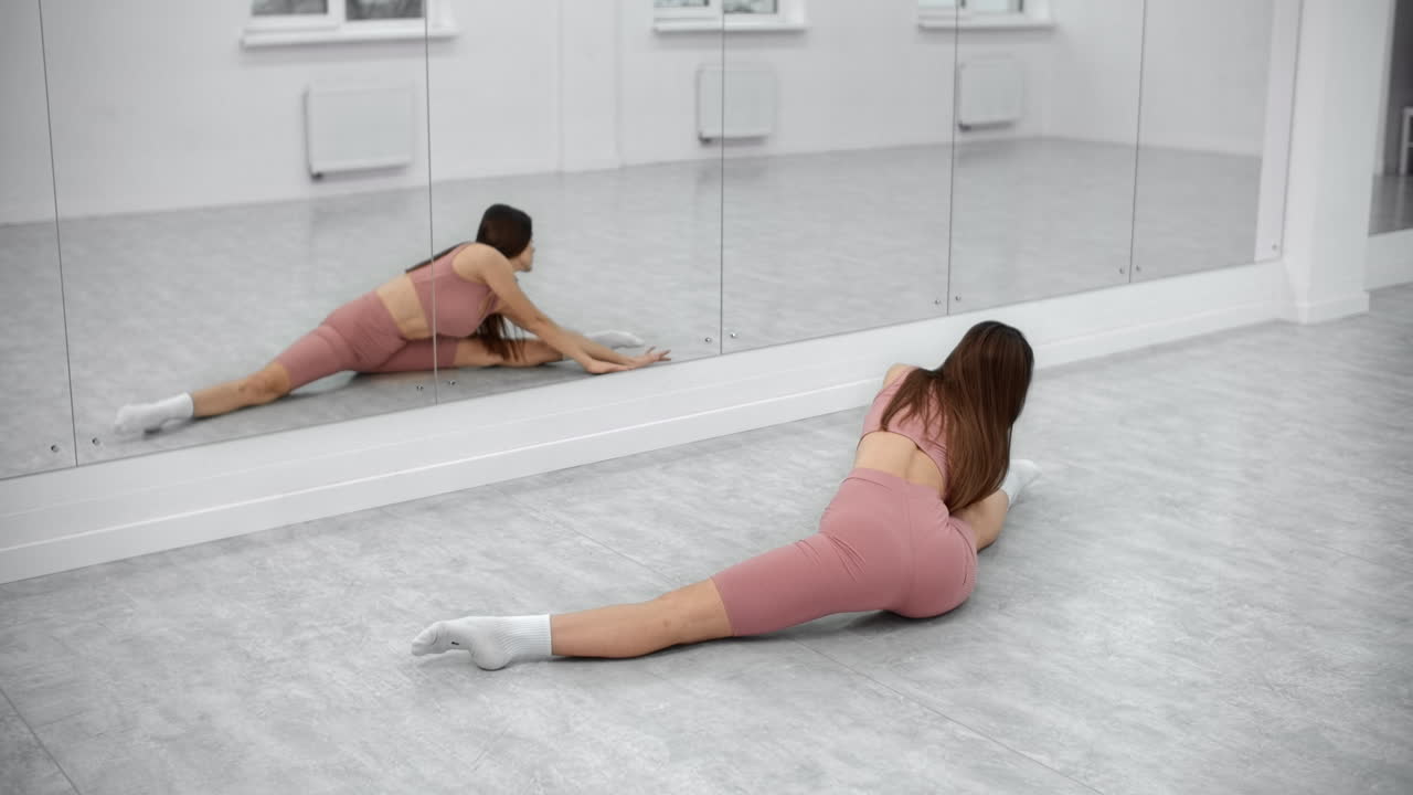 женщина растягивается в танцевальной студии