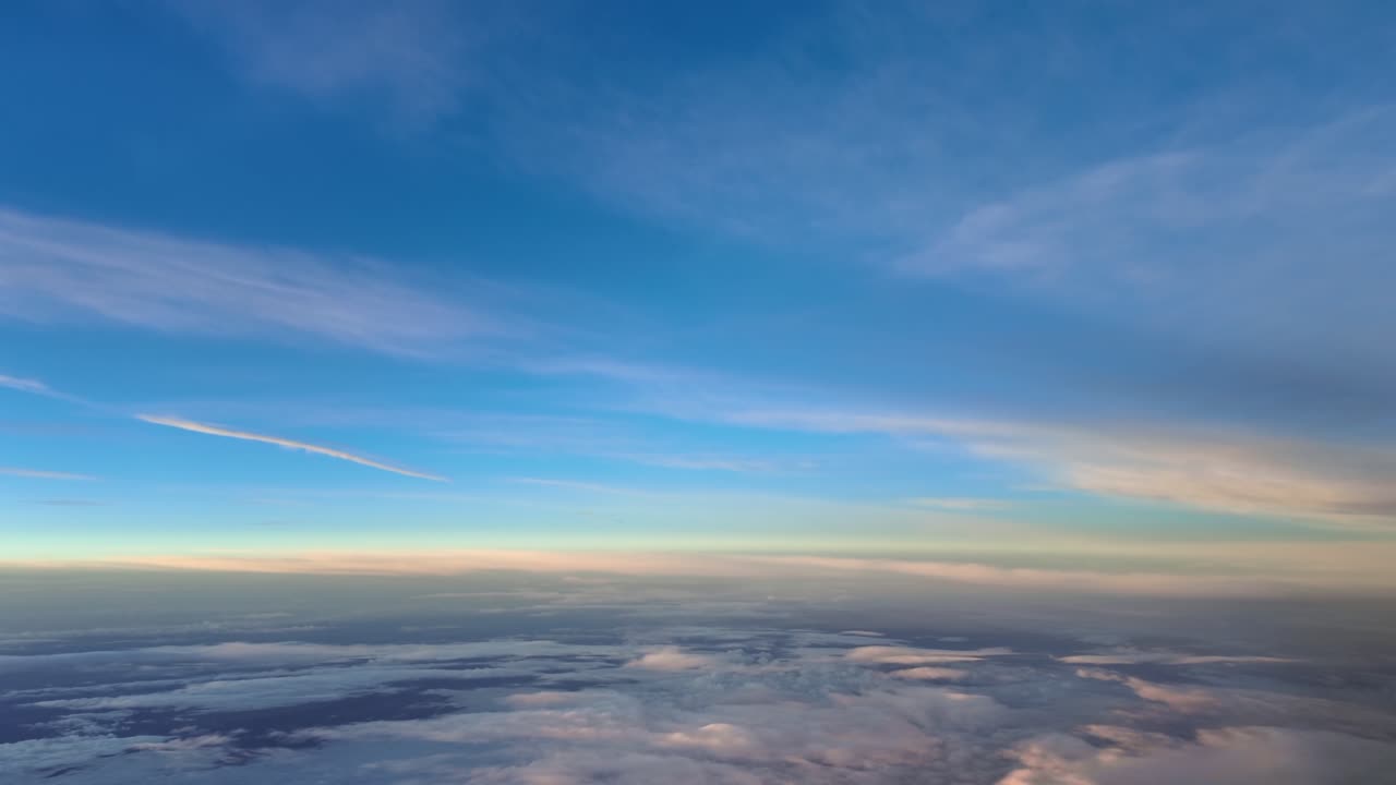 A hight-altitude flight at supersonic speed while flying at sunrise between layers of ethereal golden clouds under a blue sky. Aerial footage taken from a jet cockpit flying in the upper atmosphere