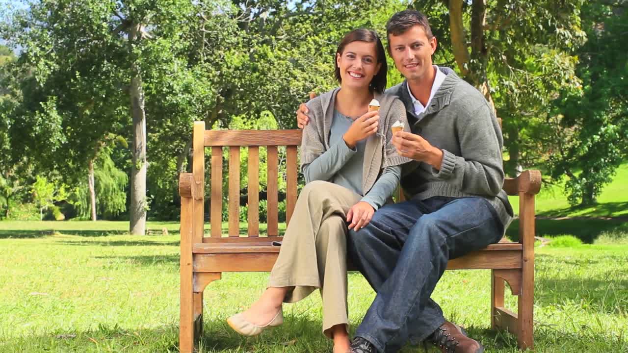 젊은 부부가 야외에서 아이스크림을 먹고 있습니다.