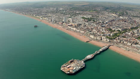 Toma-Aérea-De-Alto-Establecimiento-Sobre-El-Muelle-De-Brighton-Hacia-El-Centro-De-La-Ciudad-Y-Frente-A-La-Playa