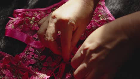 the woman prepares pink lace lingerie to sell in the store