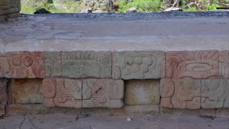 pan across carved temple stones at ancient mayan ruins of copan, hnd