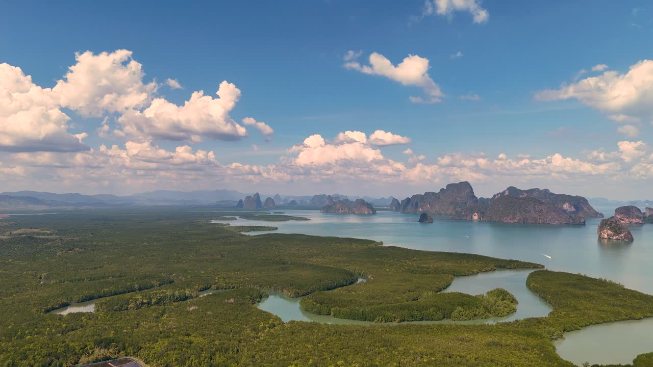드론 영상은 밝고 은 하늘 아래 태국의 phang nga bay의 울창한 풍경과 휘어지는 수로를 포착합니다.
