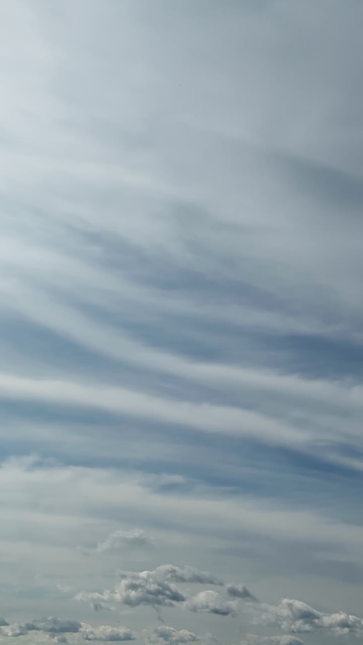 Cumulus and stratus clouds covering the sky. Grey cloudscape moving in the atmosphere. Vertical video. Timelapse.