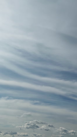cumulus and stratus clouds covering the sky. grey cloudscape moving in the atmosphere. vertical video. timelapse.