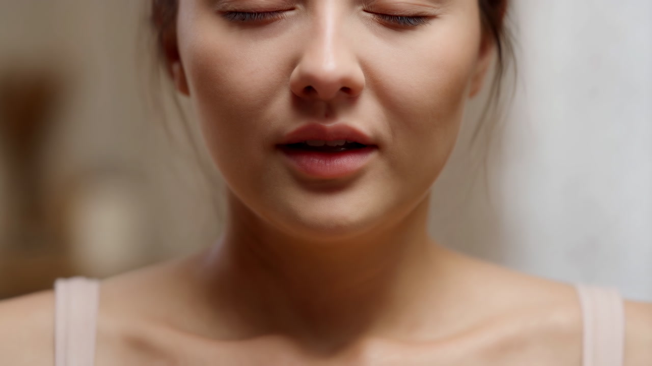 Closeup Woman Practicing Mindful Breathing In Warm Bathroom Light, Bare Shoulders, Softfocus Background,