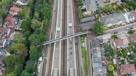 pan down drone shot over south western british rail train arriving at twickenham station