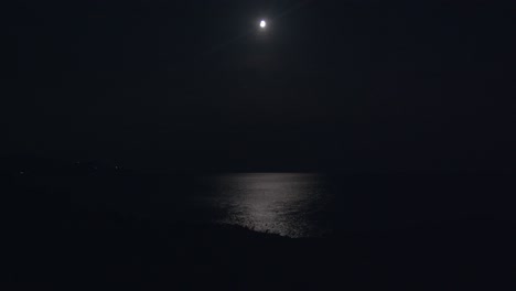 moon and moonlight reflecting over sea at night, extreme long shoot