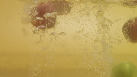 tiro de un montón de manzanas con diferentes colores caídos en el agua