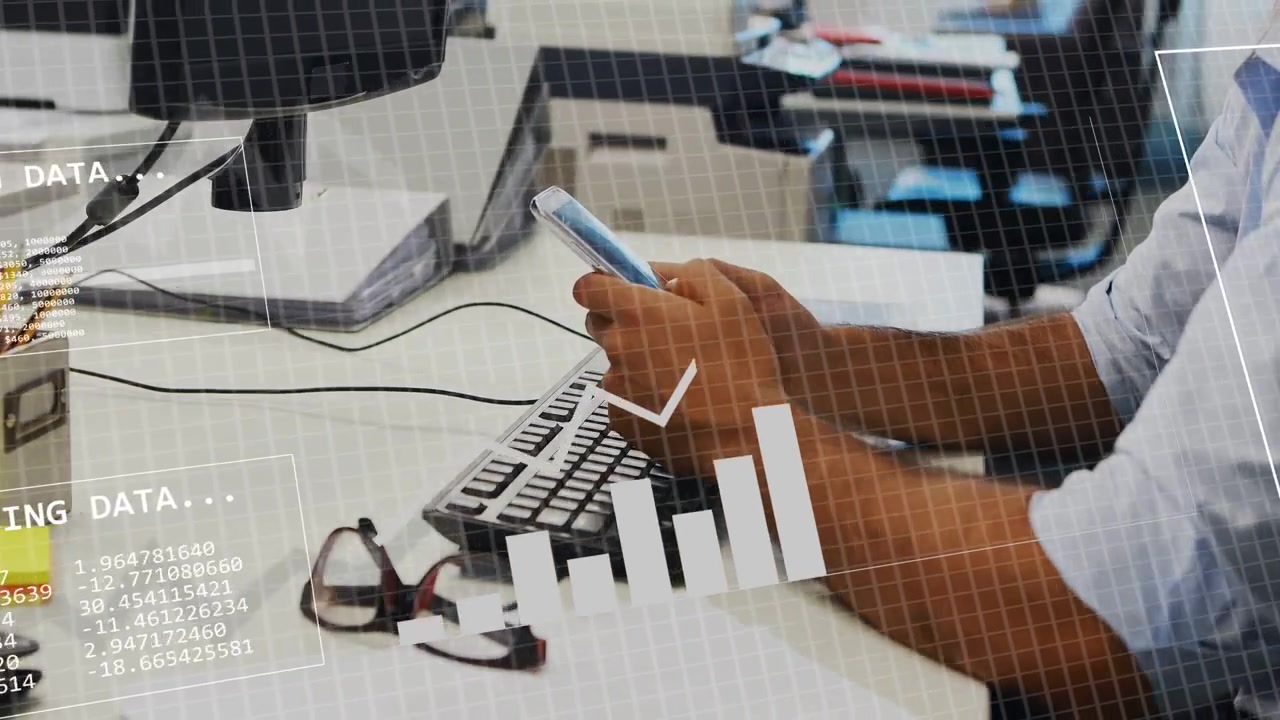 Man holding phone above keyboard, tapping and typing, animating charts and binary HUD for analytics