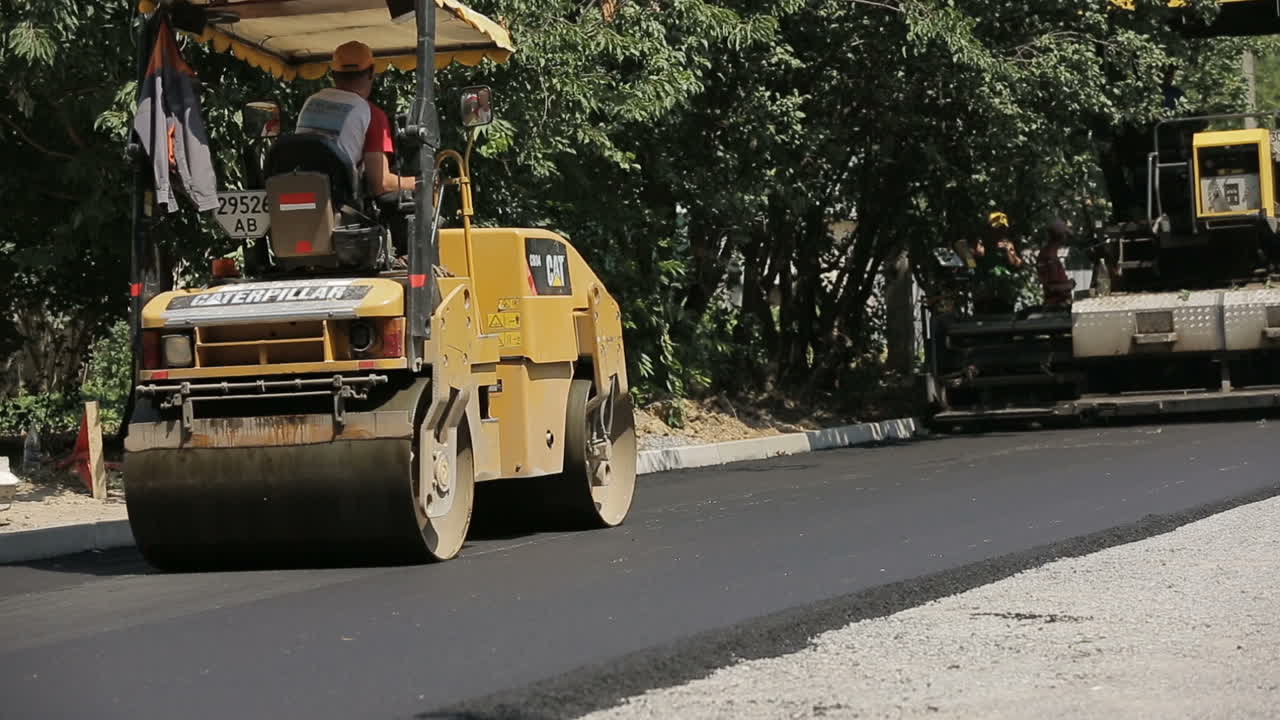 VINNITSA, UKRAINE - JULY 2017: Team of workers making and constructing asphalt road construction