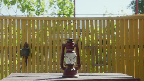 a woman places the old vintage kerosene lantern on the table - static shot