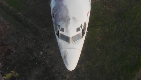 High-angle-shot-of-old-rusty-airplane-at-Bali-Indonesia-during-sunrise,-aerial