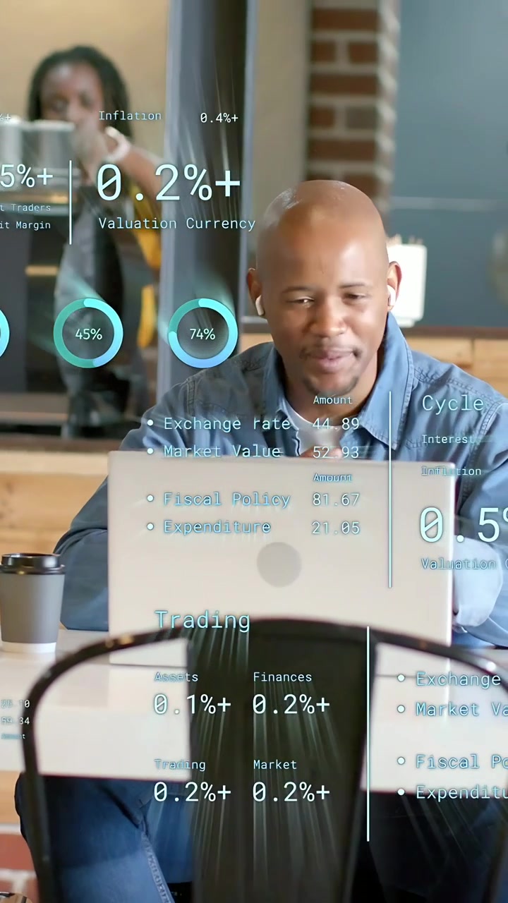 Vertical video: Seated man joining call in cafe, finance HUD updating laptop charts about trades