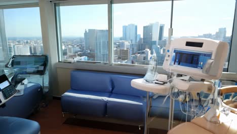 comfortable treatment chair with medical equipment in bright hospital room