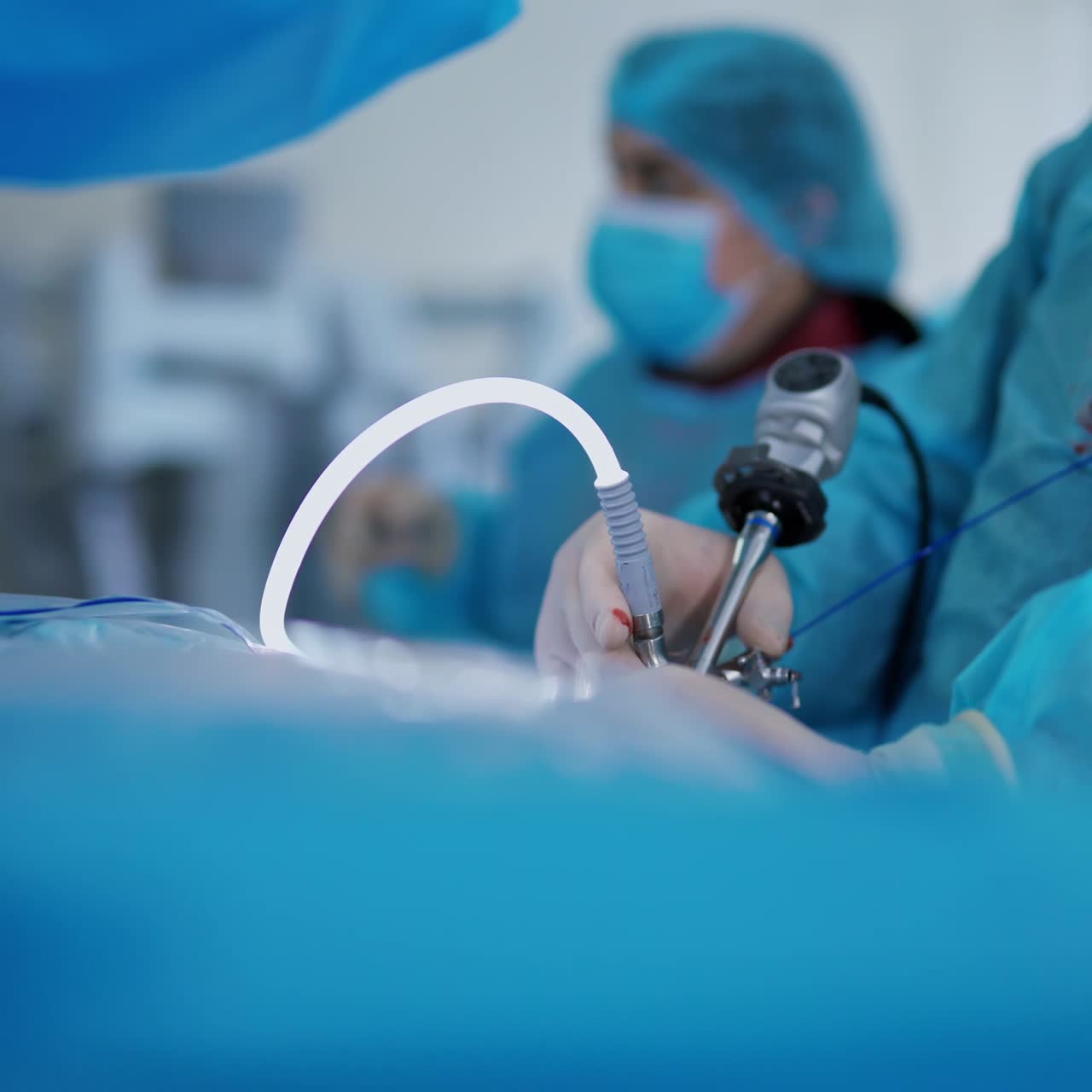 Modern medical device in surgeon's hands during surgery. Specialist conducting an operation on kidneys to a patient. Close-up.
