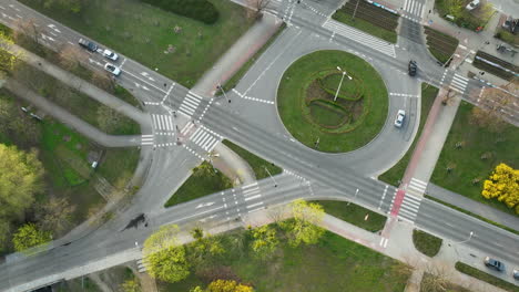 Luftaufnahme-Eines-Kreisverkehrs-Mit-Seinem-Geordneten-Verkehrsfluss-Und-Den-Zebrastreifen-Inmitten-Der-Grünflächen-Einer-Stadtlandschaft