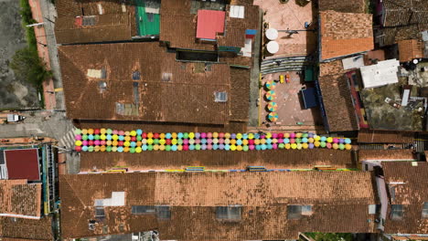 aerial top down shot above a umbrella street in the guatape town, sunny colombia