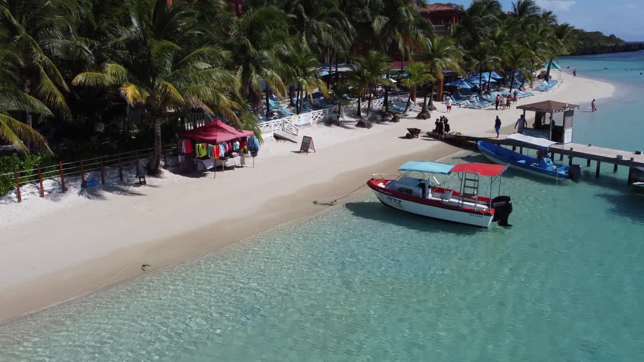 Barche ormeggiate su una spiaggia di sabbia bianca di un incantevole resort balneare a Roatan.