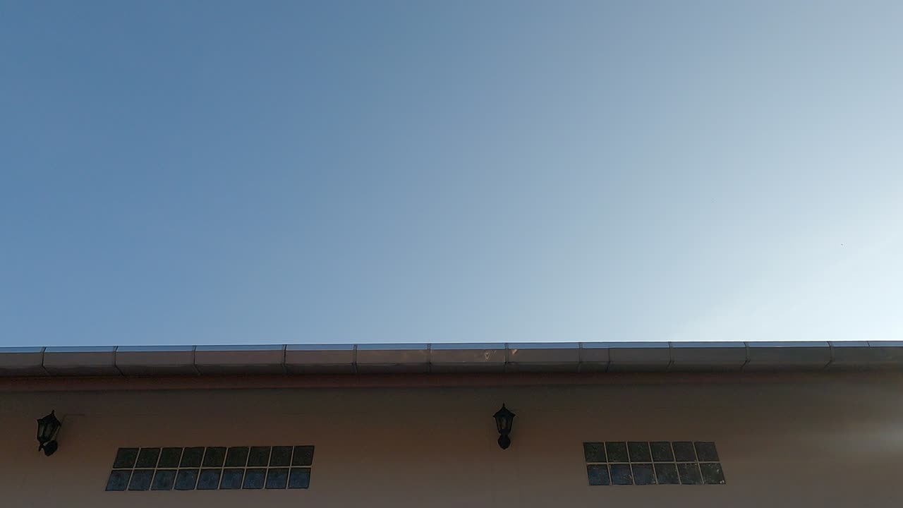 el sol brillante de la mañana el rayo de luz brillando al amanecer el cielo azul sobre el techo de la casa