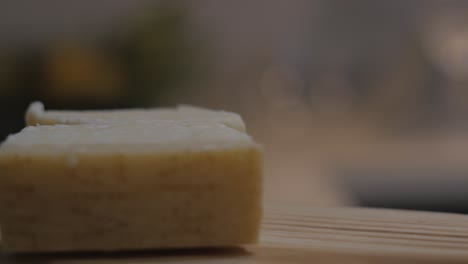 Parmesan-cheese-fresh-pieces-rotating-on-wooden-table---Portugal