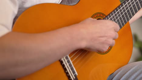 Primer-Plano-De-Un-Hombre-Tocando-La-Guitarra-Amarilla-Con-Los-Dedos