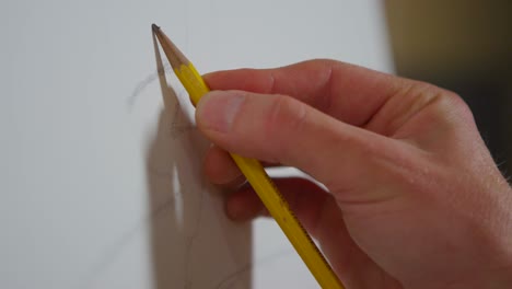 closeup of a hand as an artist begins to sketch on a blank canvas 1