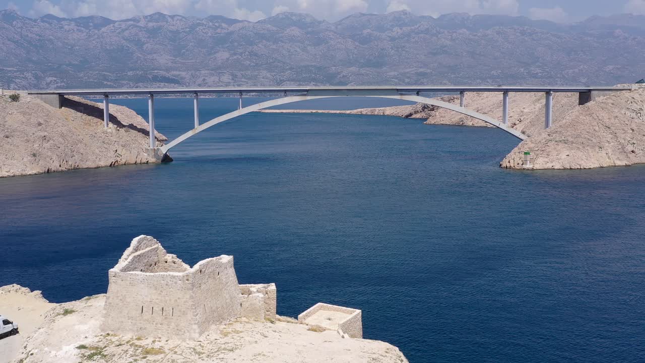 Paski Most Bridge seen from Ruine Fortica joining Otok Pag island to the Croatian mainland, Aerial flyover shot