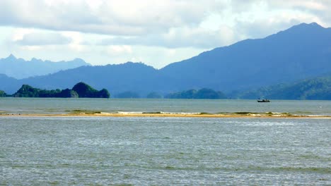 vista de la costa con vistas al mar y las montañas con suaves olas en unas vacaciones con buen tiempo, provincia de satun, tailandia