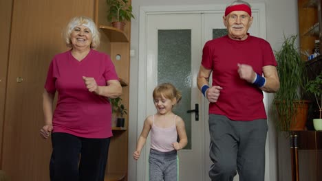 Active-old-senior-couple-grandmother-grandfather-with-child-kid-girl-doing-fitness-running-exercises