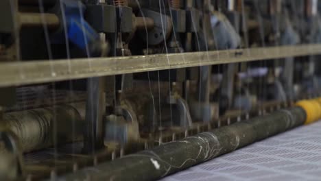 spinning machinery and spindles in a production making a mattress for a bed, close up shot in a factory