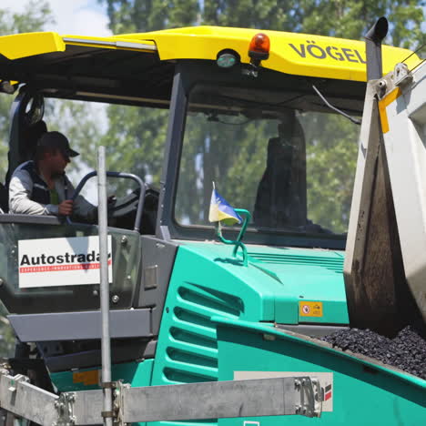road machinery for laying asphalt. industrial pavement truck outdoors. road repairs. driver sitting in a truck during roadworks.