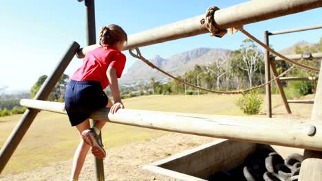 girl exercising on outdoor equipment during obstacle course