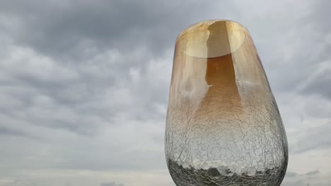 Beautiful-heat-cracked-empty-glass-flower-vase-with-stunning-rainy-day-cloud-time-lapse-background-and-water-drops-falling