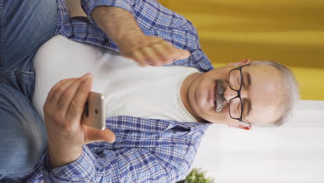 Vertical-video-of-The-phone-of-the-old-man-talking-on-the-phone-runs-out-of-charge.