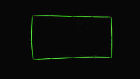Animation-of-green-neon-glow-sticks-forming-rectangle-over-black-background-with-copy-space