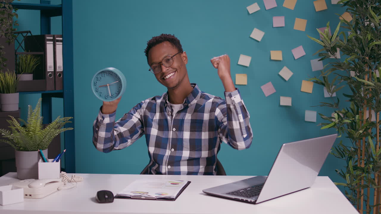 Happy employee checking time on clock and finishing work