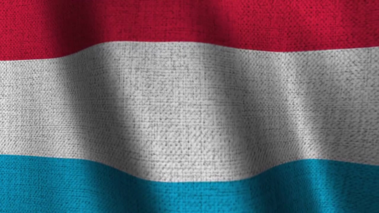 Bandiera tricolore del Lussemburgo in tessuto che sventola.