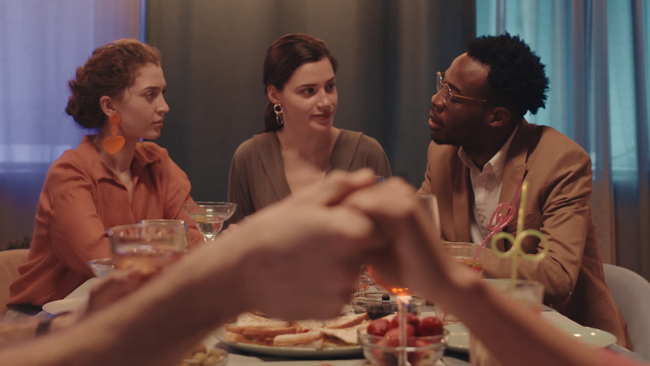 Couple Holding Hands at Friends Dinner